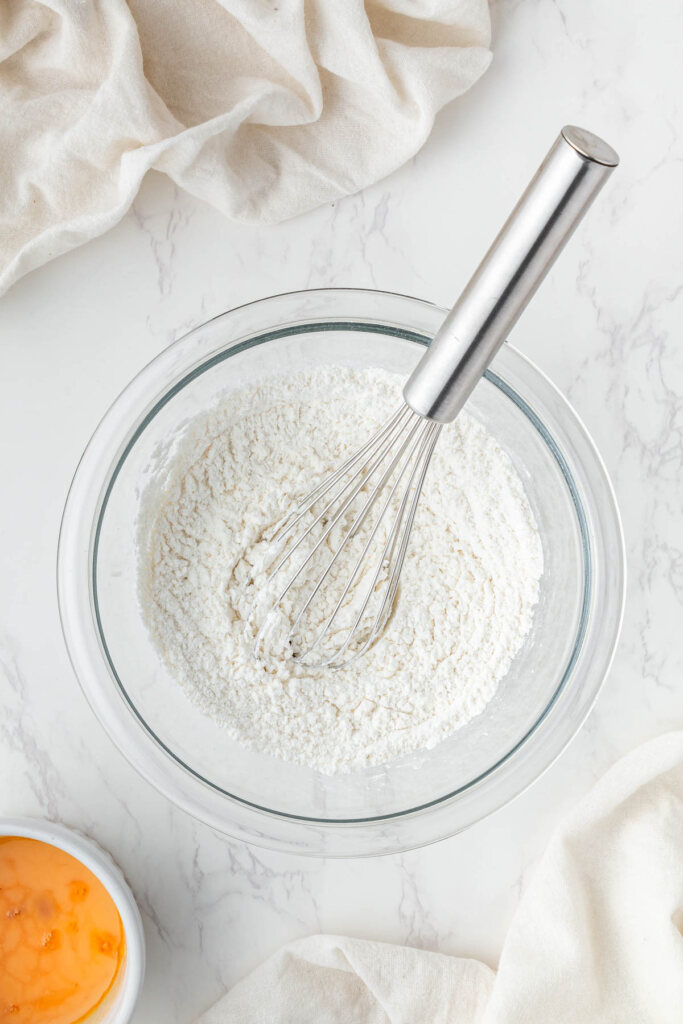 flour in a clear mixing bowl with whisk