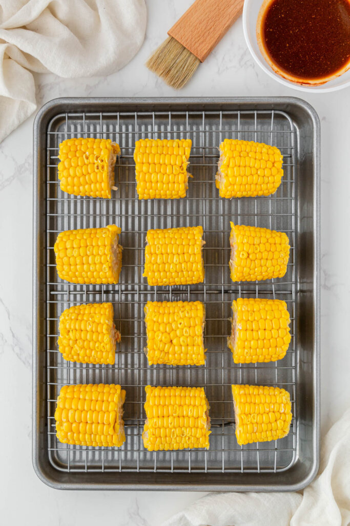 overhead view of yellow corn on cooling rack on baking sheet