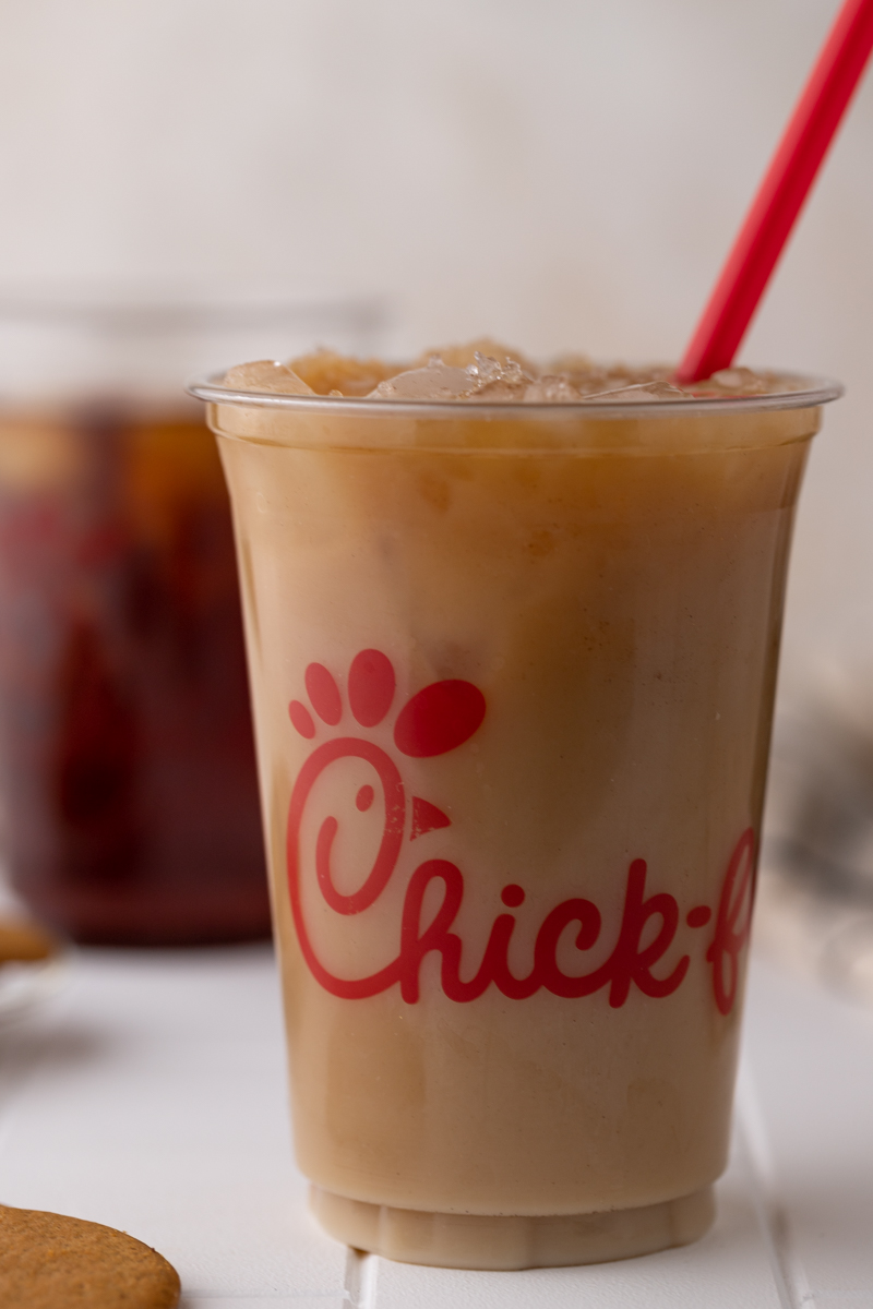 side view of a cup of Chick Fil A iced coffee with a straw in it