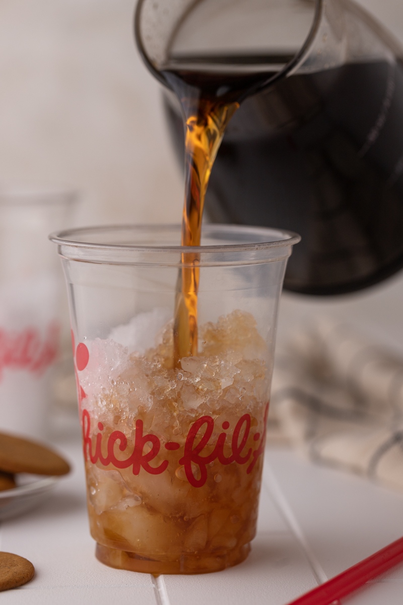 cold brew being poured into a cup of ice