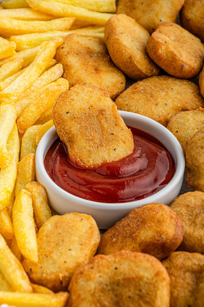 McDonald's Chicken Nugget getting dipped into ketchup with fries