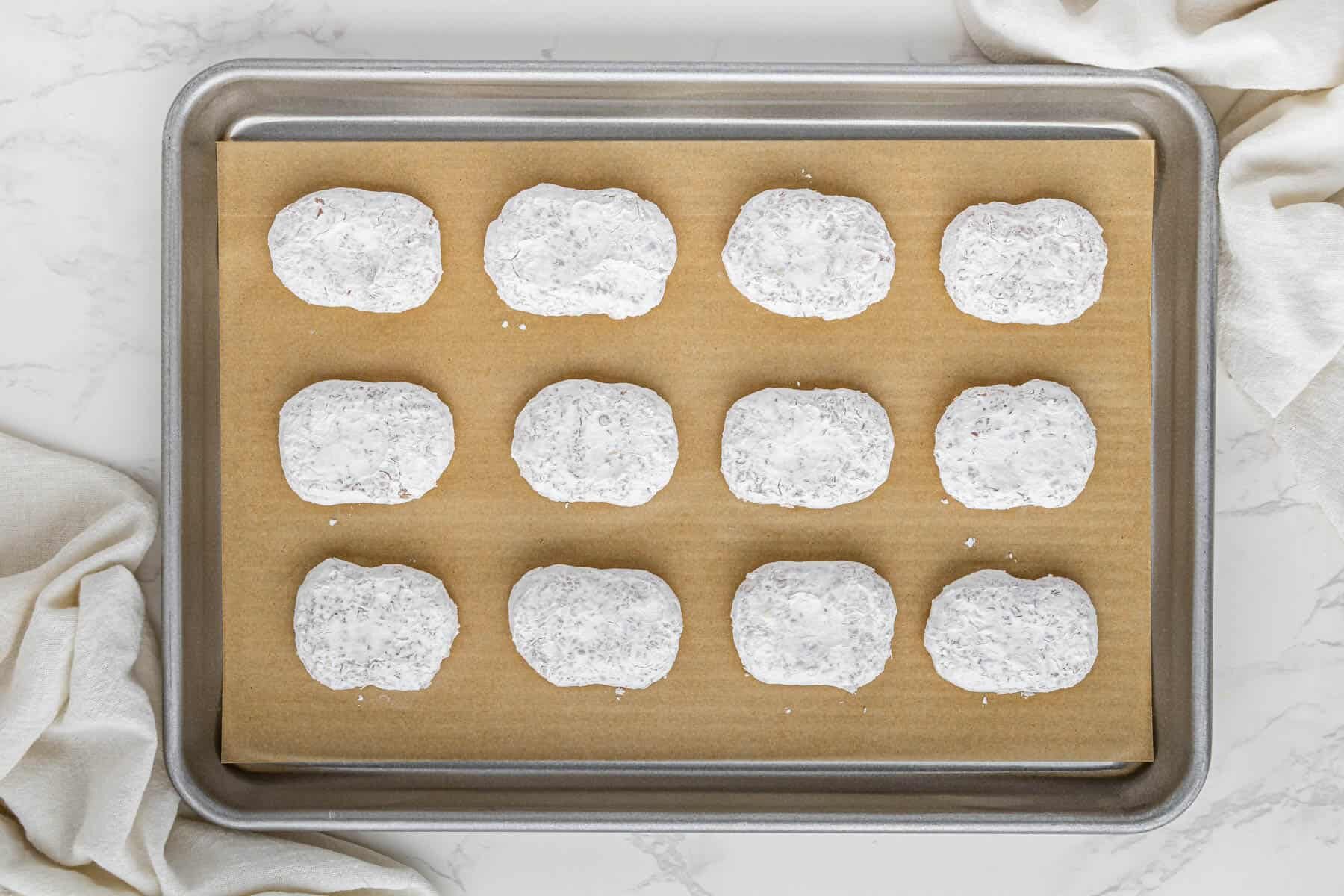 uncooked chicken nuggets on baking sheet with parchment paper