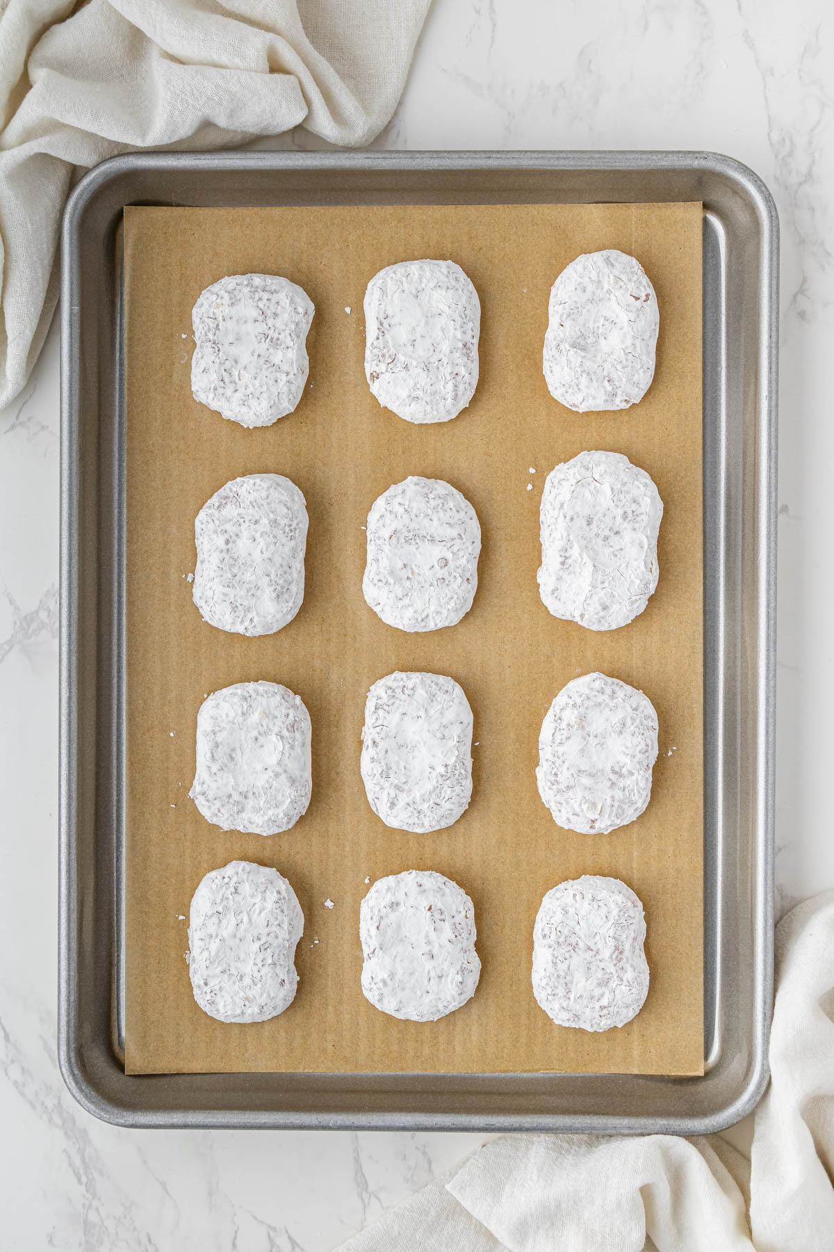 uncooked chicken nuggets on baking sheet with parchment paper