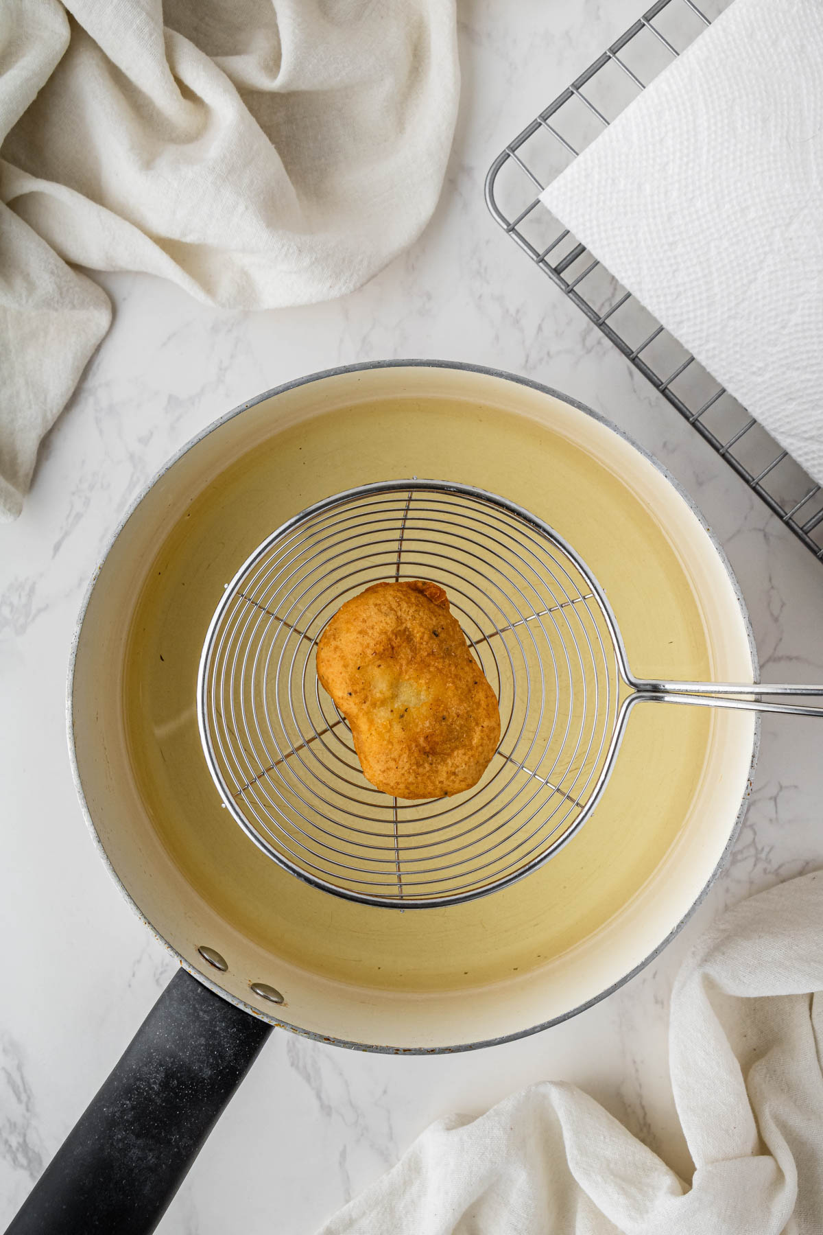 overhead view of cooked chicken nugget in coming out of air fryer