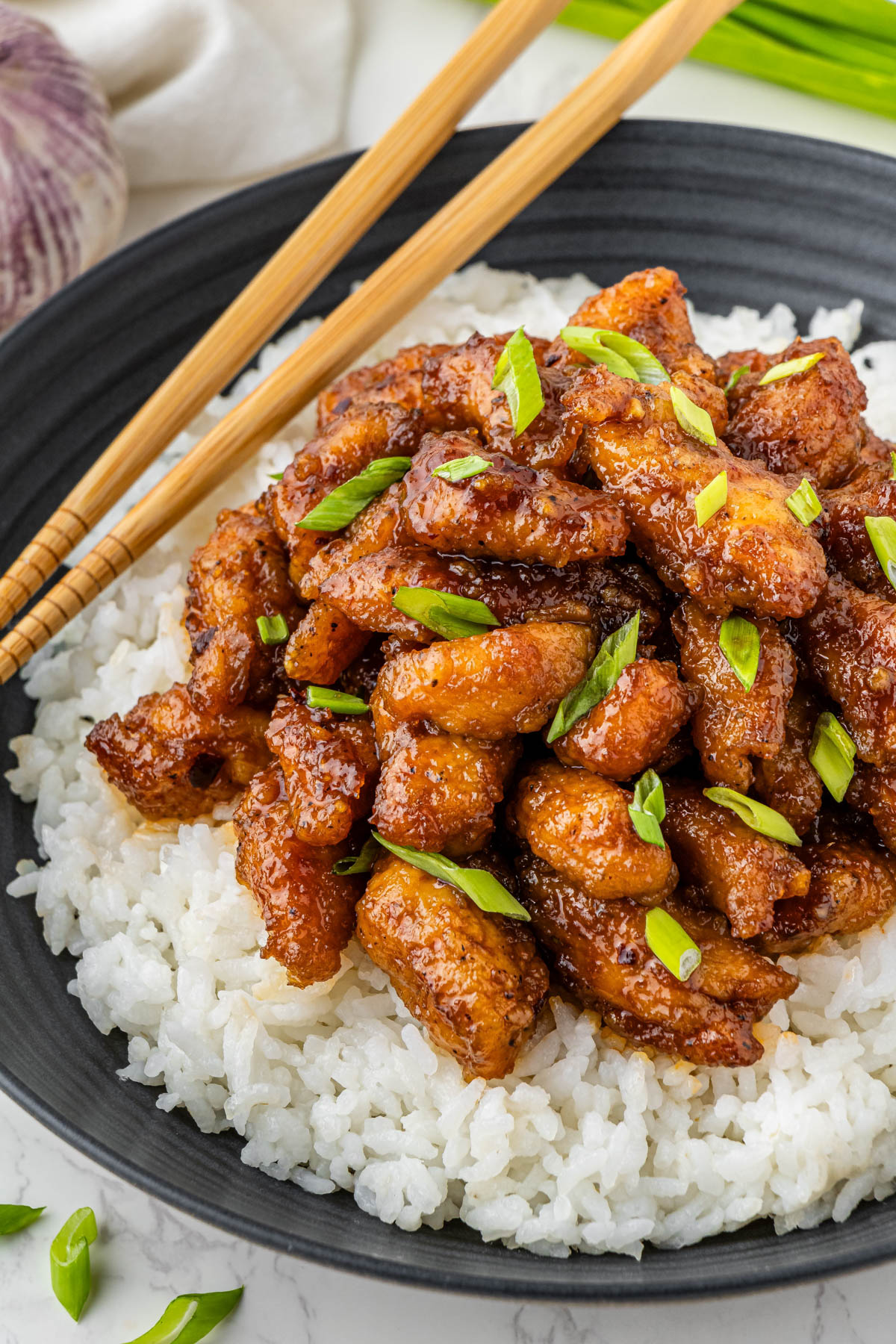 Panda Expres Bourbon Chicken on a bed of rice with chopsticks