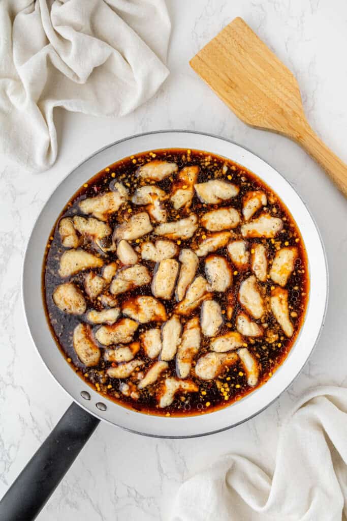 Chicken simmering in bourbon chicken sauce