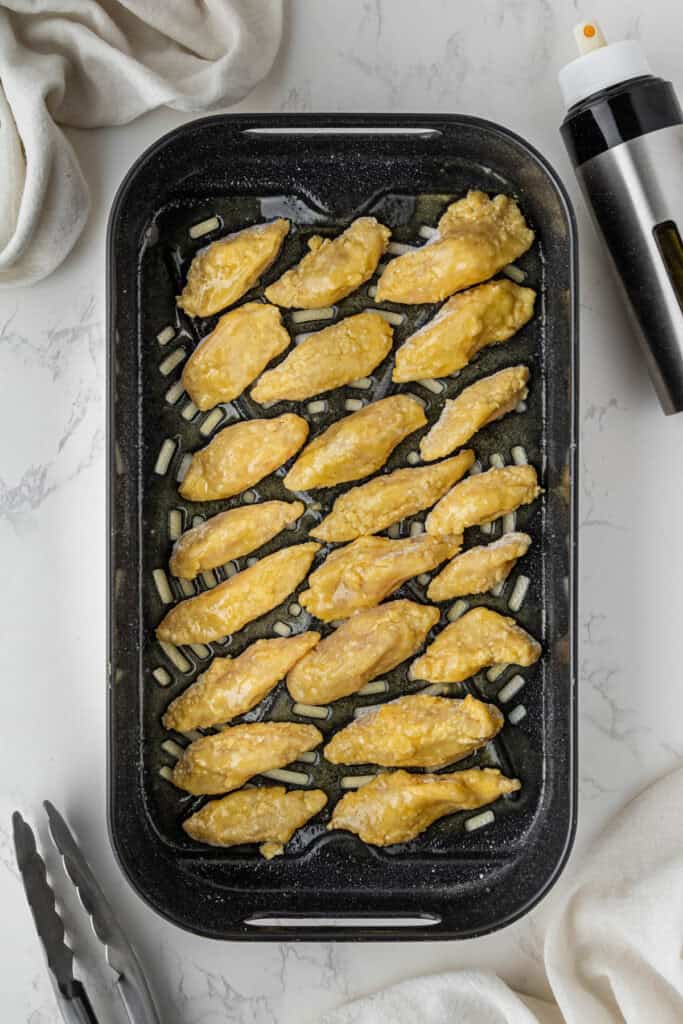 overhead view of cooked chicken pieces in air fryer basket