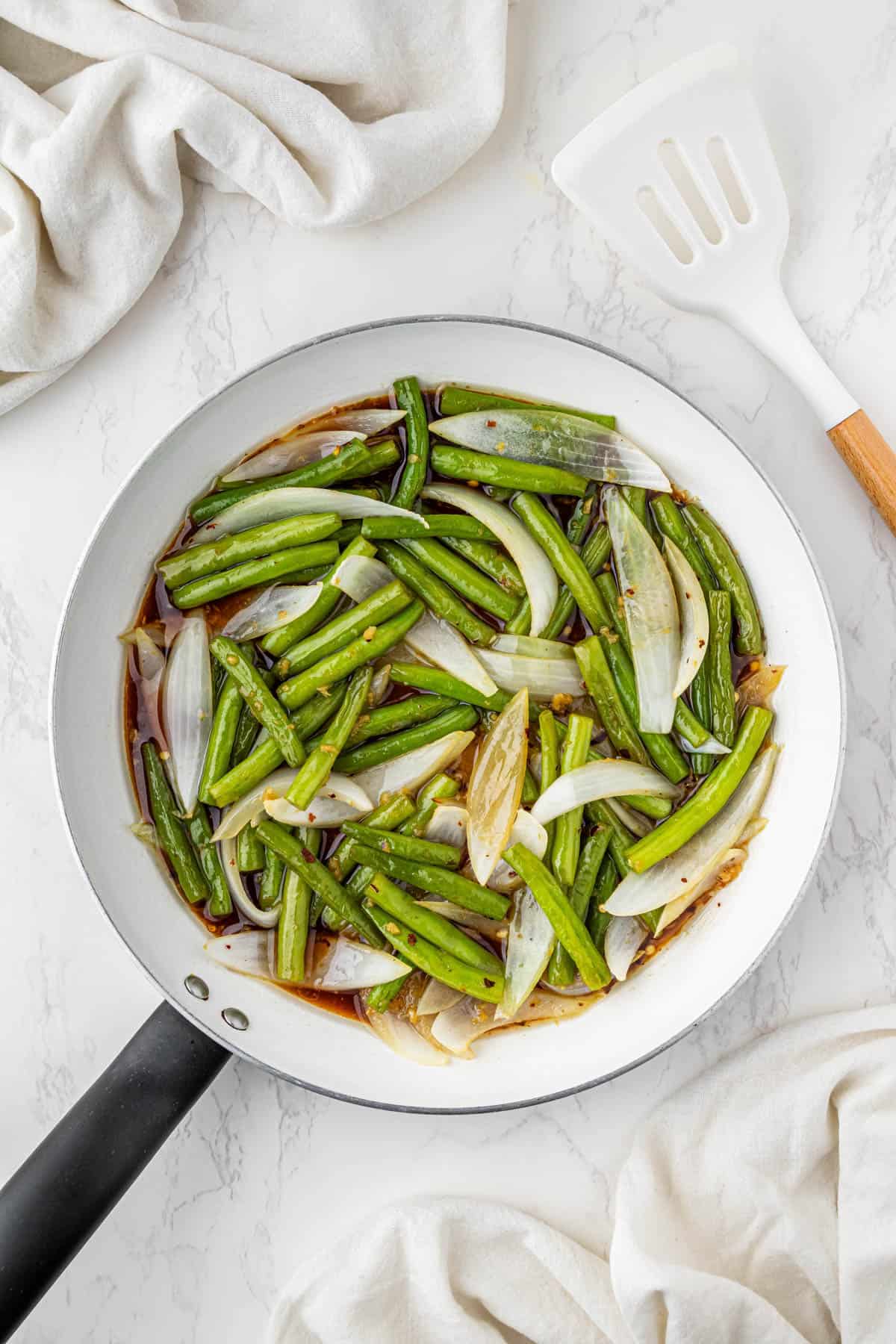 overhead view of cooked peppers, onions and sauce in a pan