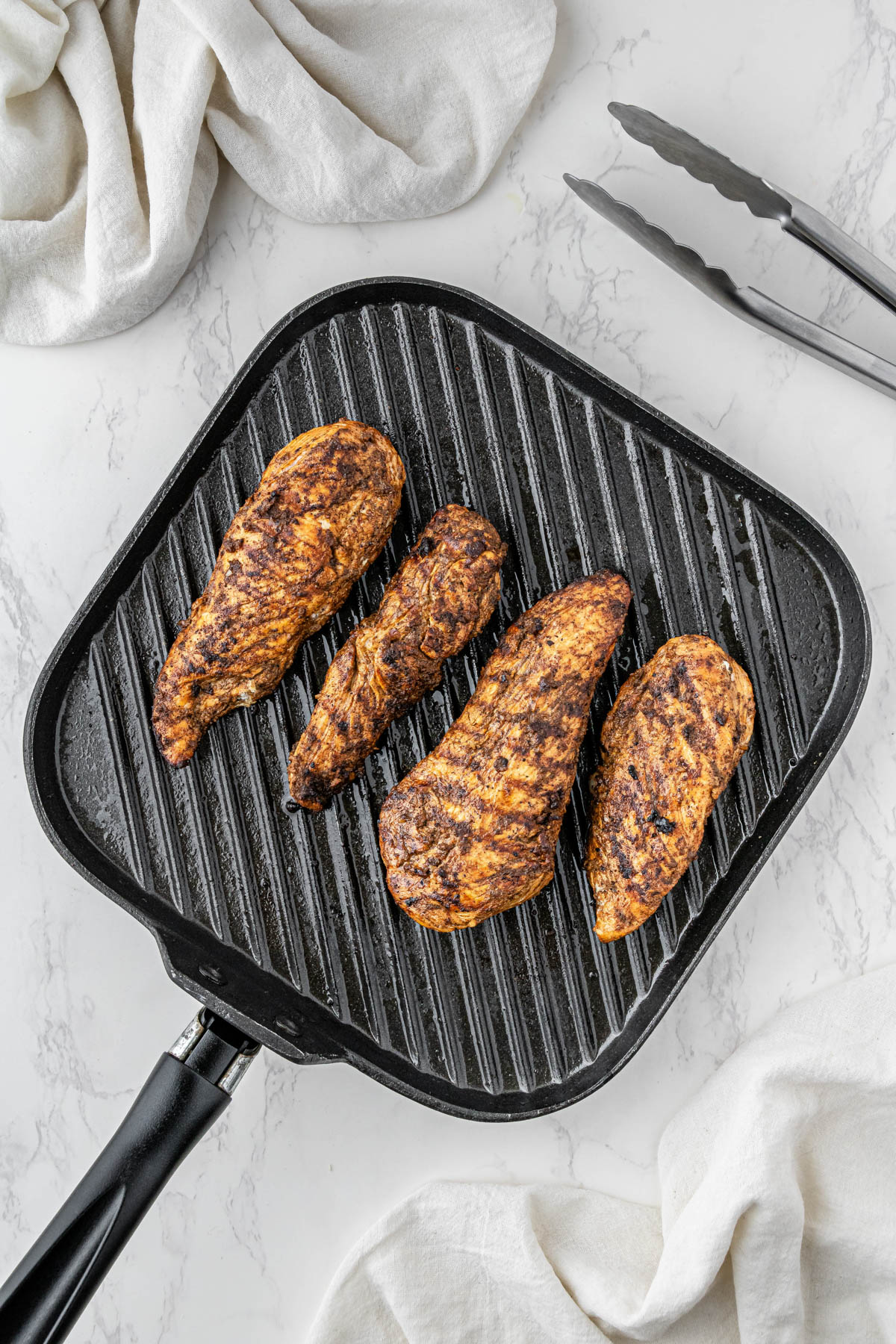 4 marinated chicken breasts on pan