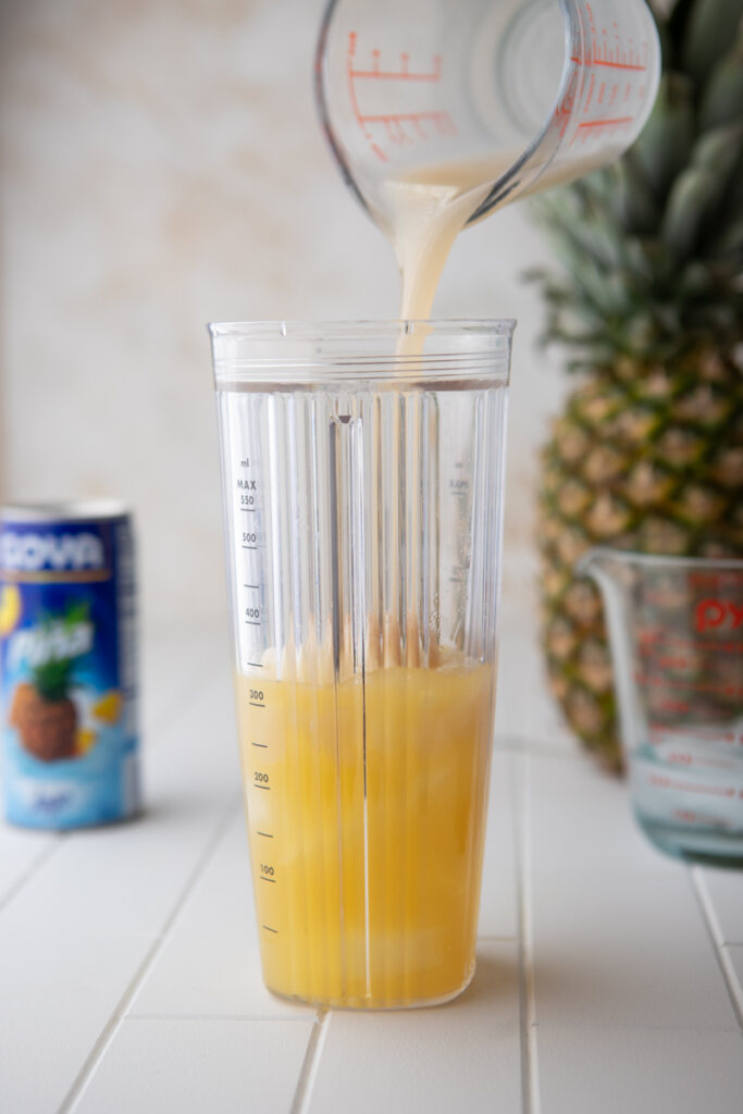 pineapple juice and coconut cream in a blender