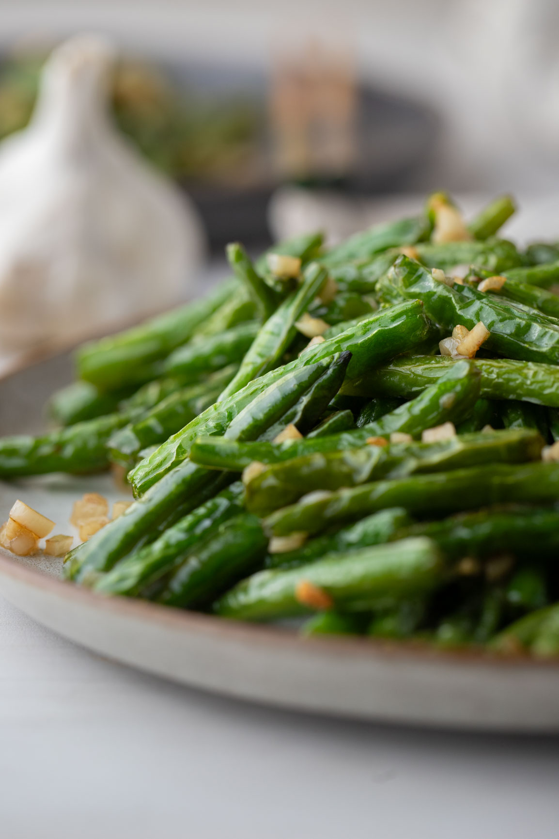 close up of din tai fung Green Beans with garlic on a white plate