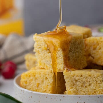 individual squares of krusteaz cornbread getting honey drizzled on it