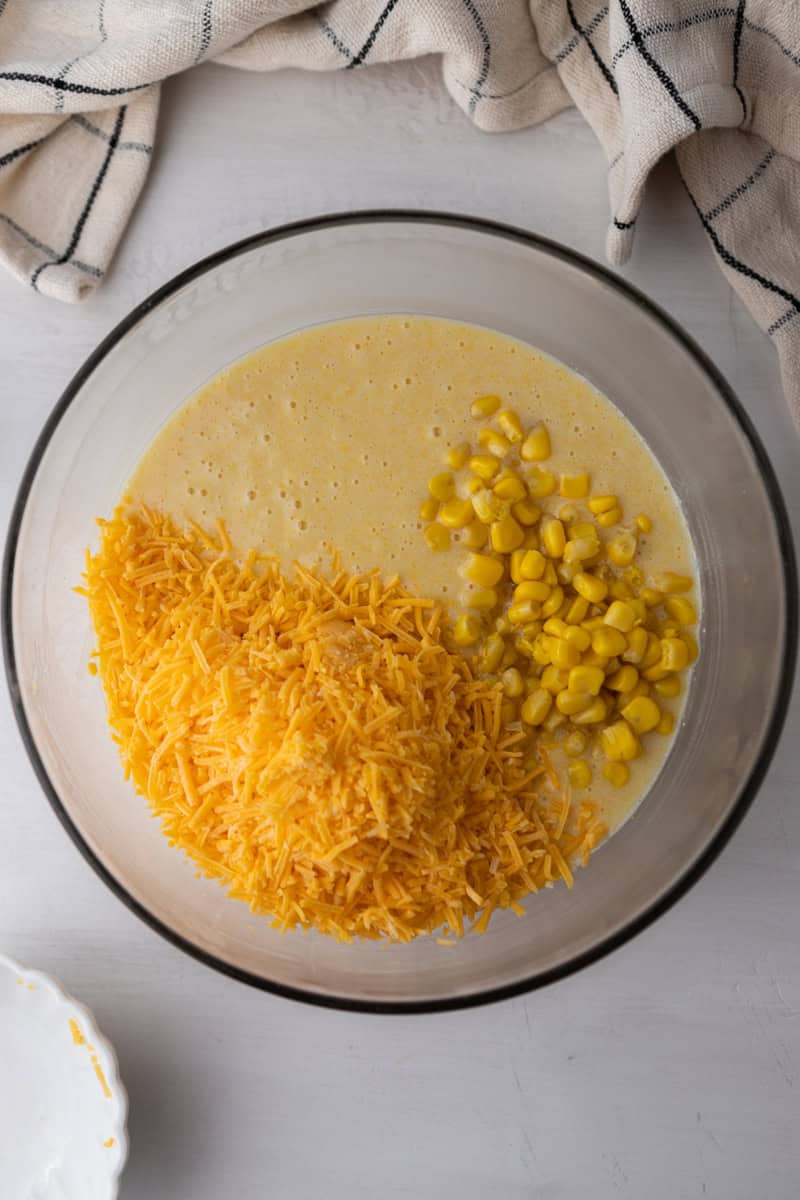 an unmixed bowl of batter, corn, and cheese