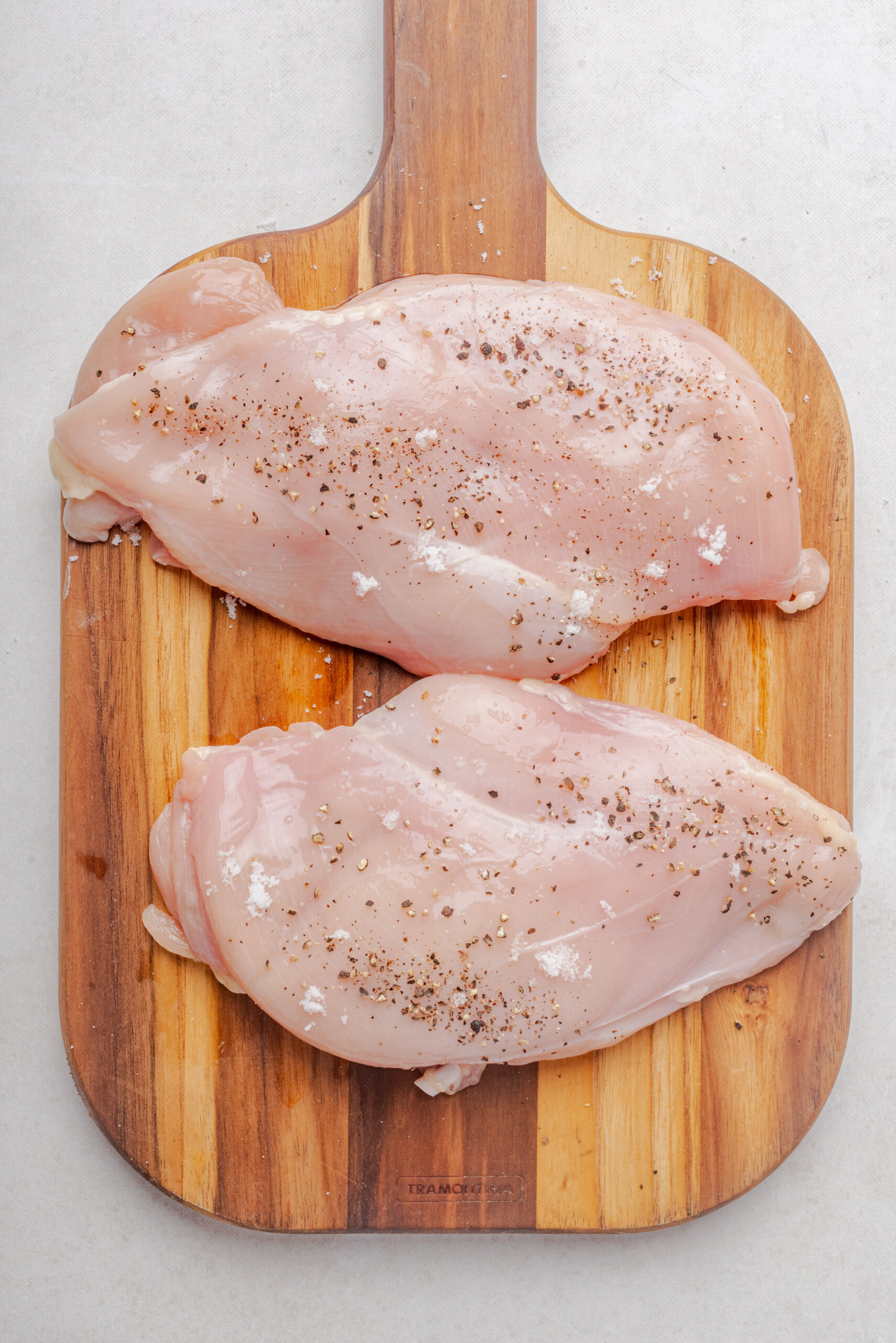 chicken breasts on wooden cutting board