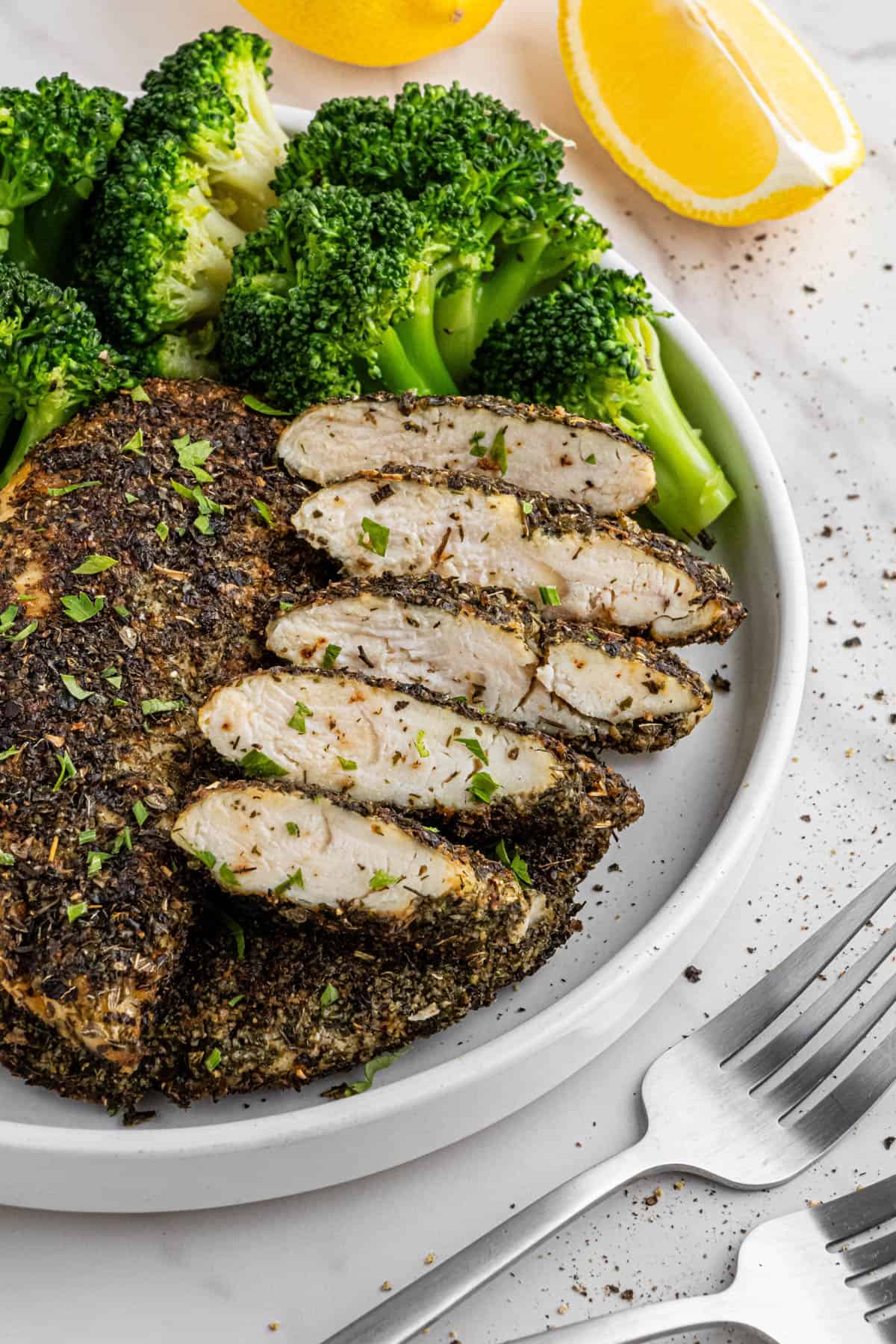 overhead view of Texas Roadhouse chicken with lemon and broccoli on side