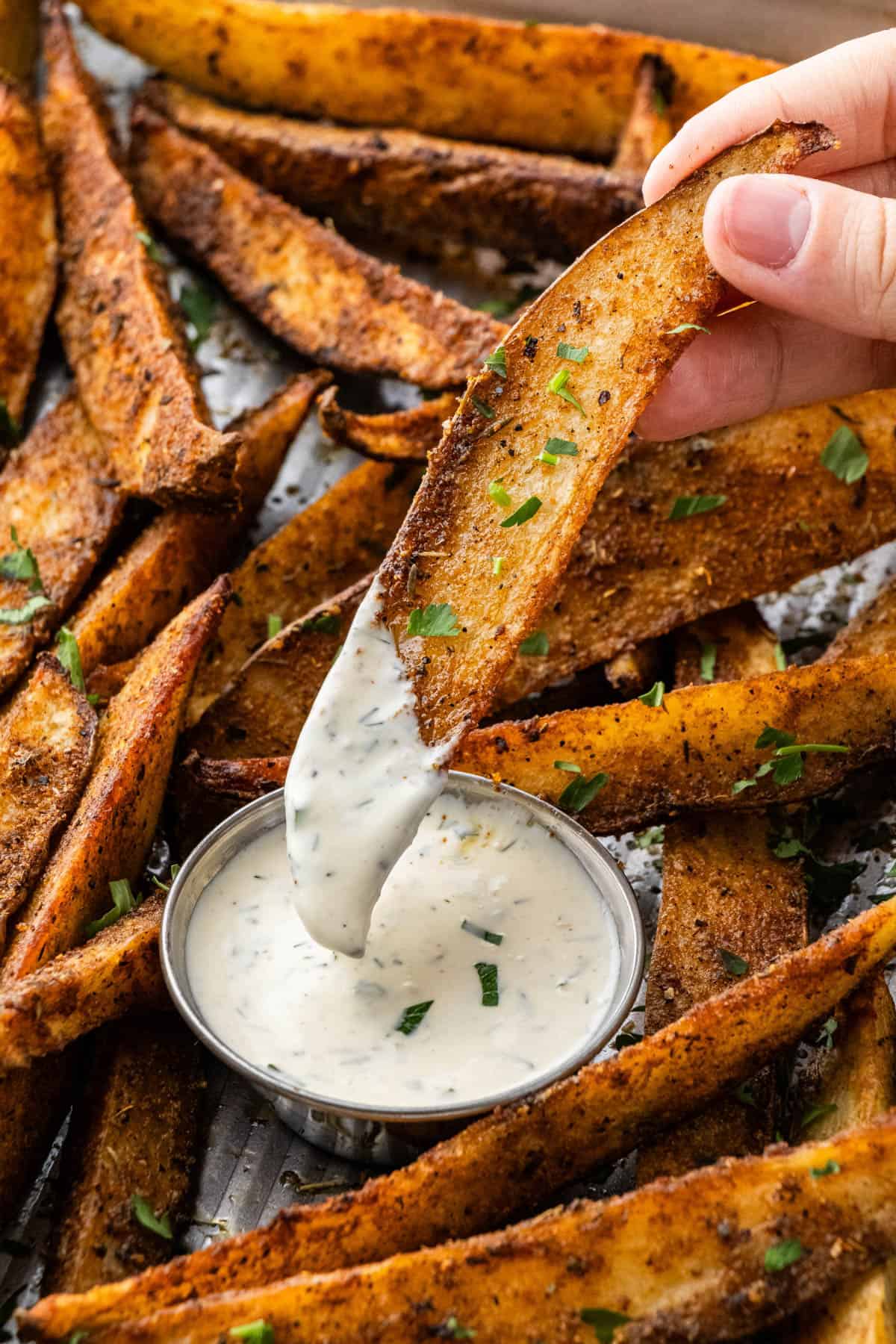 copycat buffalo wild wings potato wedges being dipped into a ranch cup