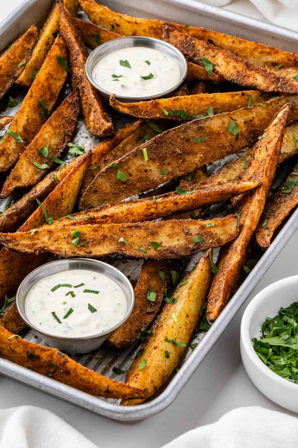 cup of ranch surrounded by seasoned copycat buffalo wild wings potato wedges