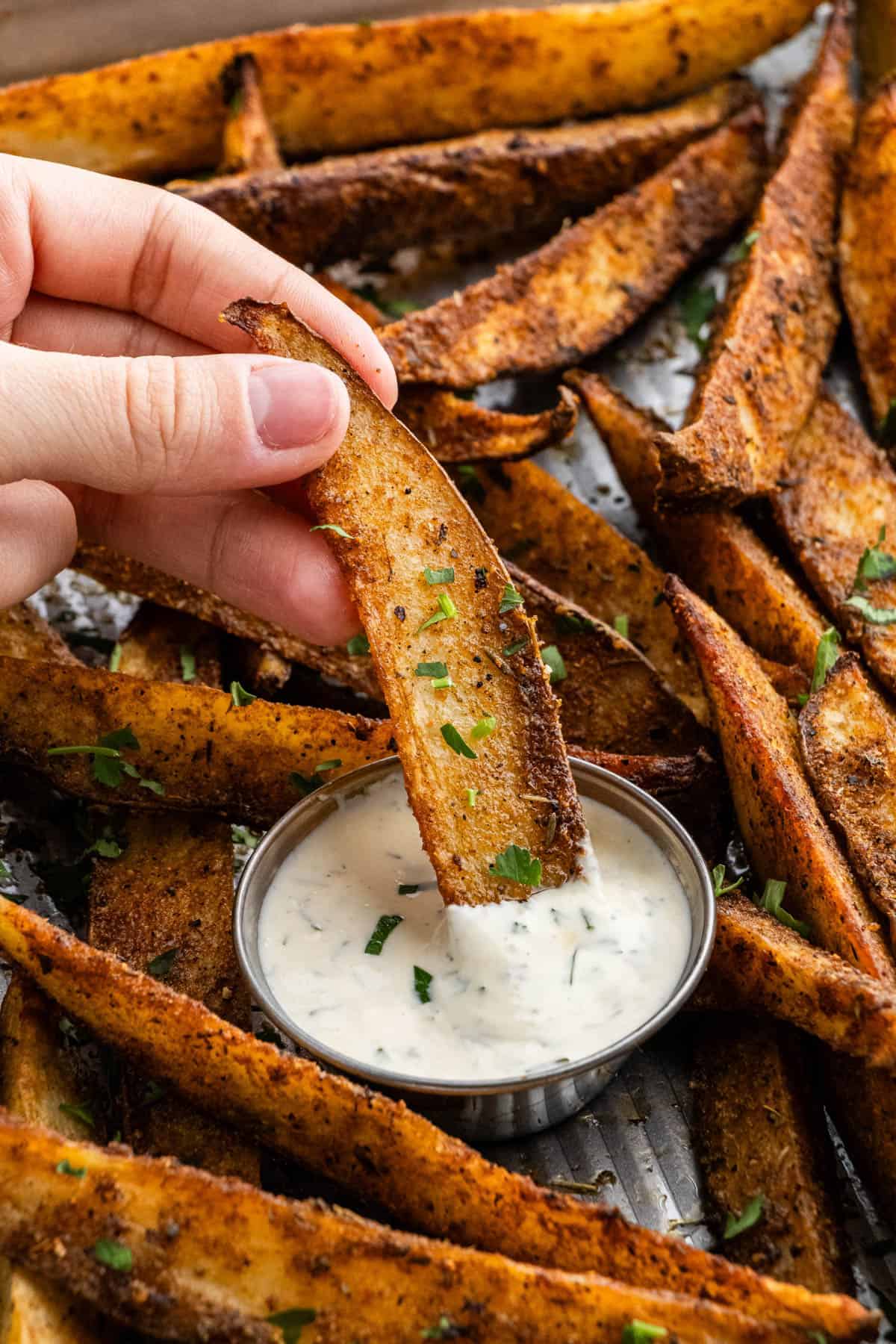 copycat buffalo wild wings potato wedges being dipped into a ranch cup