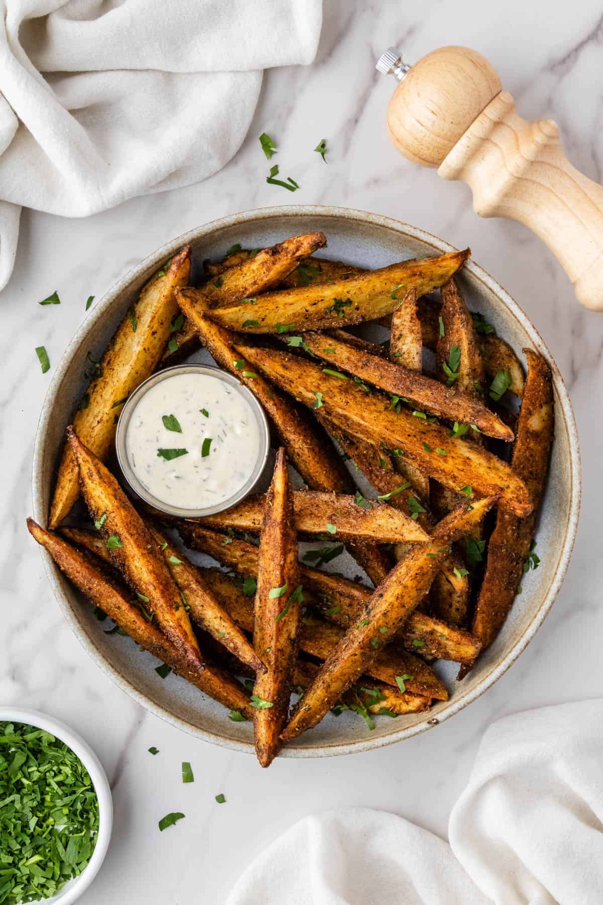 cup of ranch surrounded by seasoned copycat buffalo wild wings potato wedges