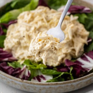Jason's Deli chicken salad on bed of mixed greens in a bowl with a silver fork