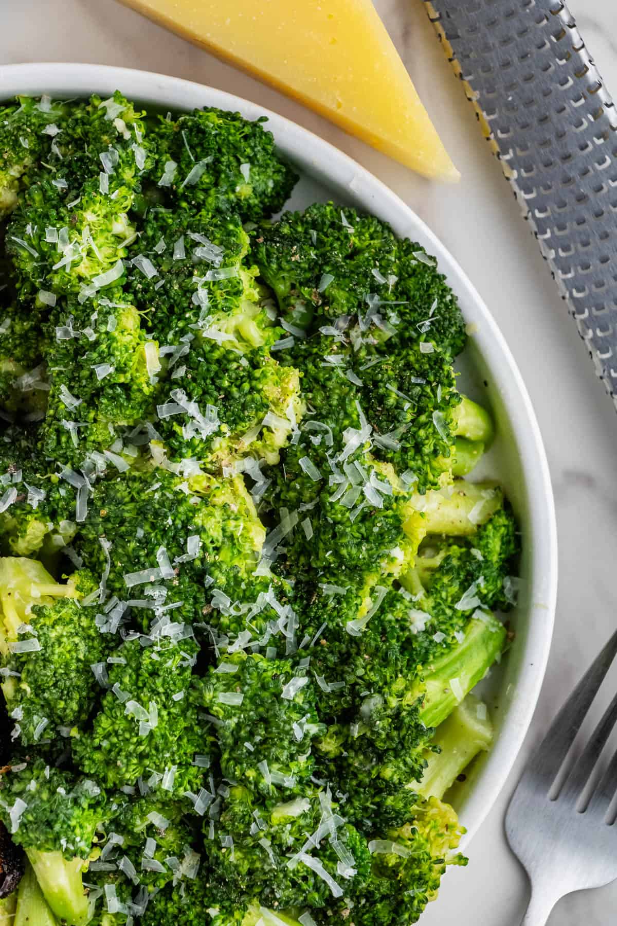 close up of Longhorn Steakhouse Broccoli recipe with cheese on white plate