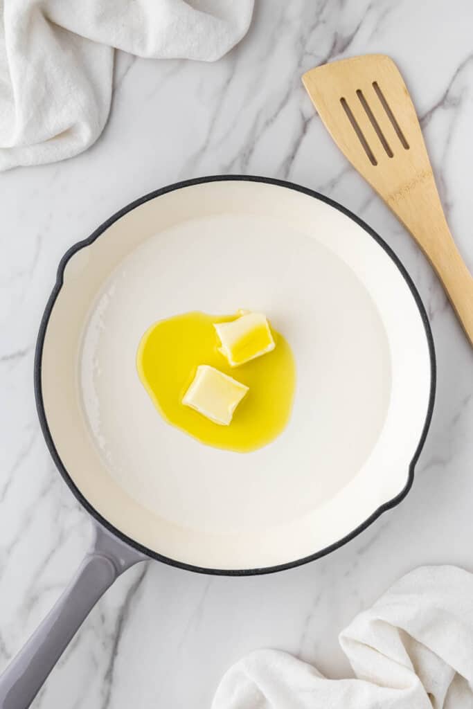 butter in white pan with wooden spatula