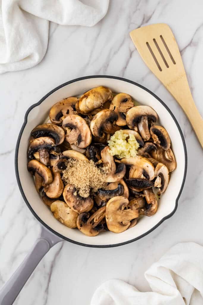 vegetables in white pan with garlic with wooden spatula