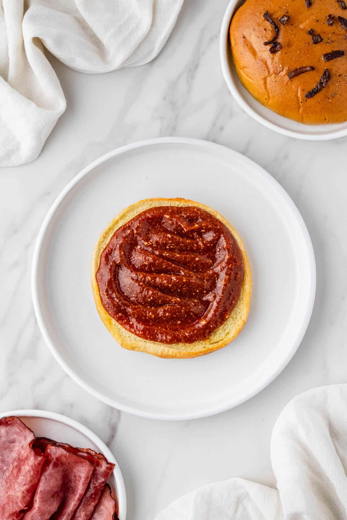 sauce spread onto a hamburger bun