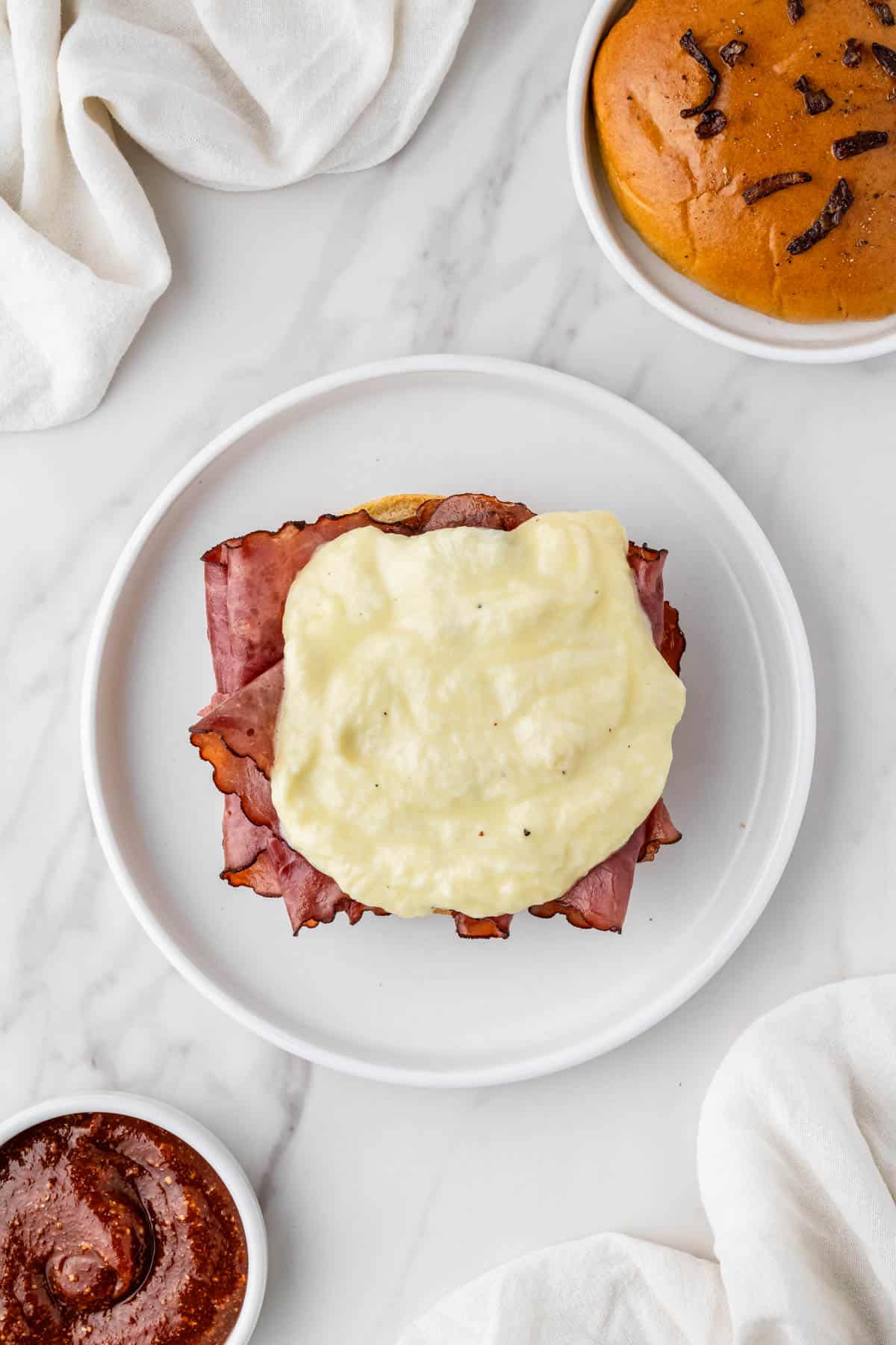 cheese sauce on top of meat on hamburger bun