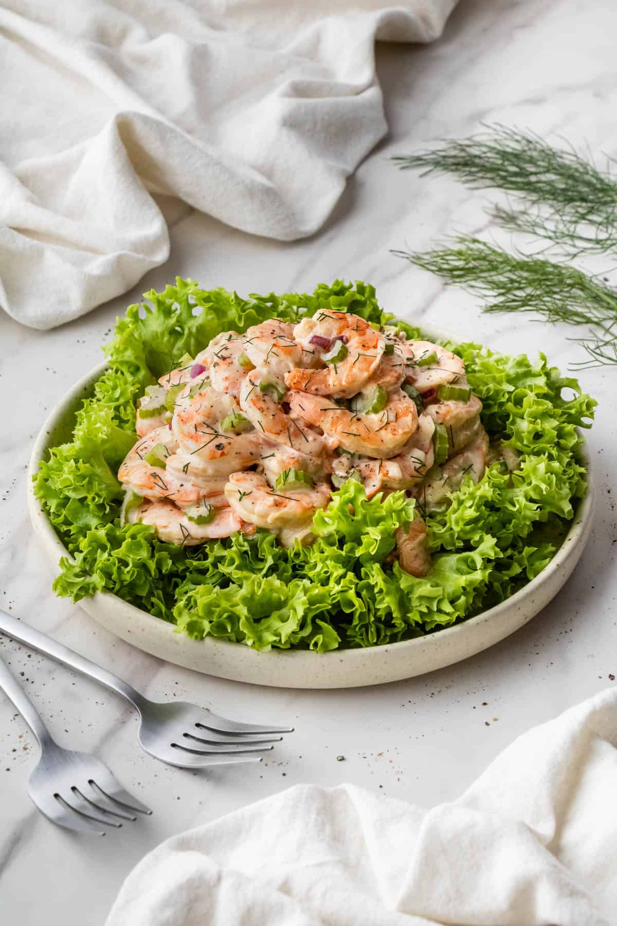 Old Bay Shrimp Salad on a bed of greens in white bowl