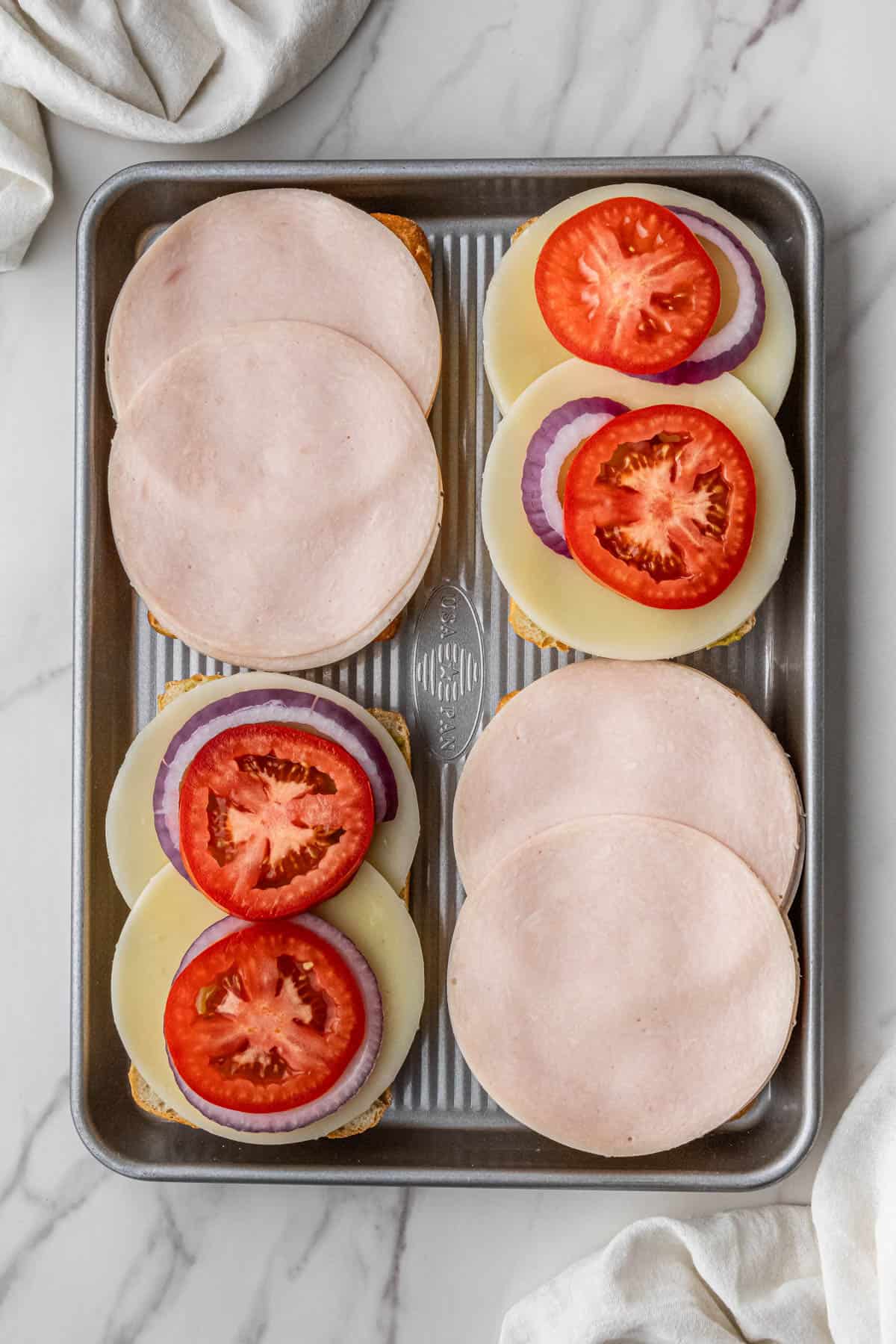 ingrdients on two slices of bread on baking sheet