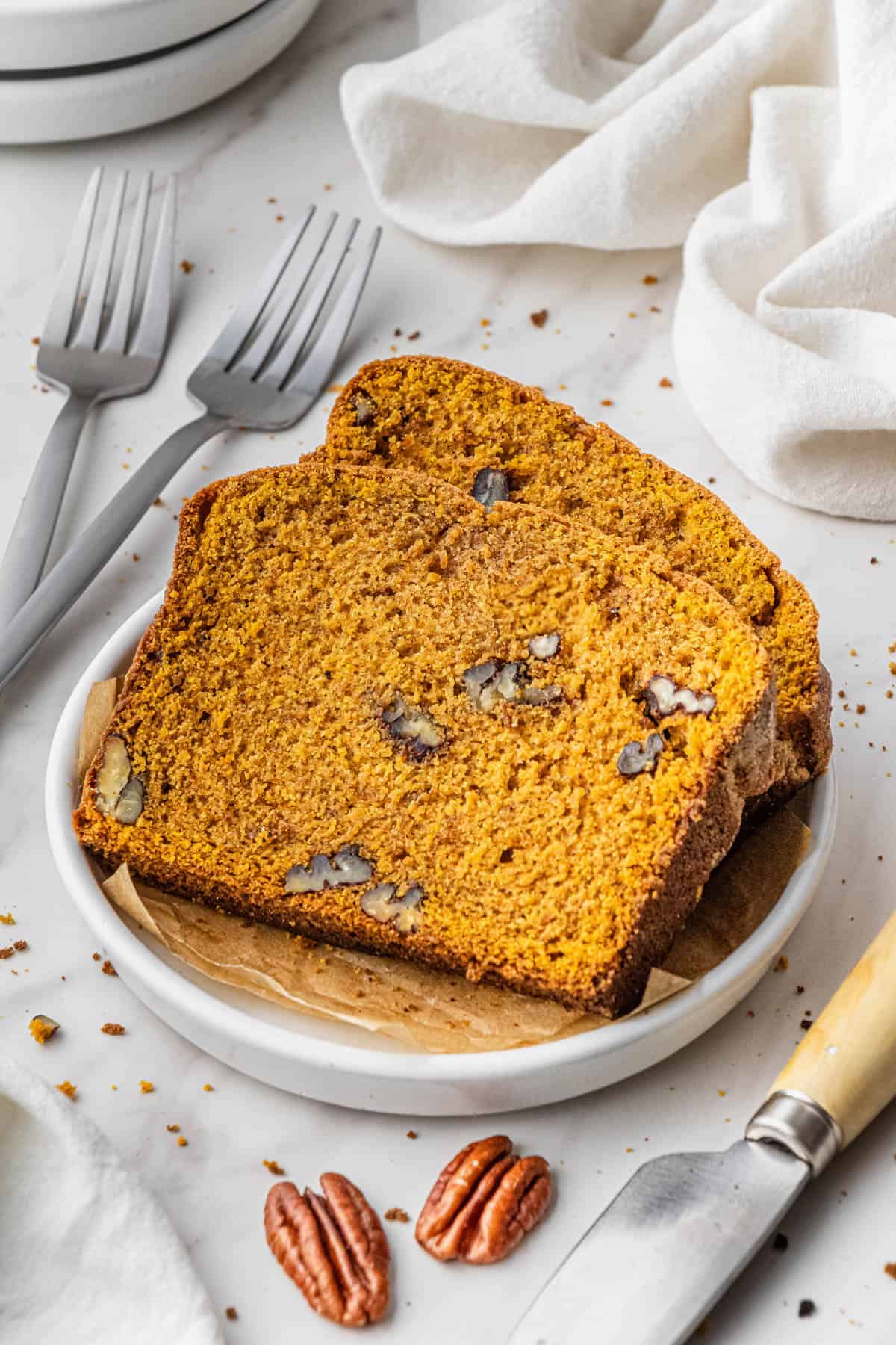 slices Libby's pumpkin bread recipe with chopped nuts on white plate