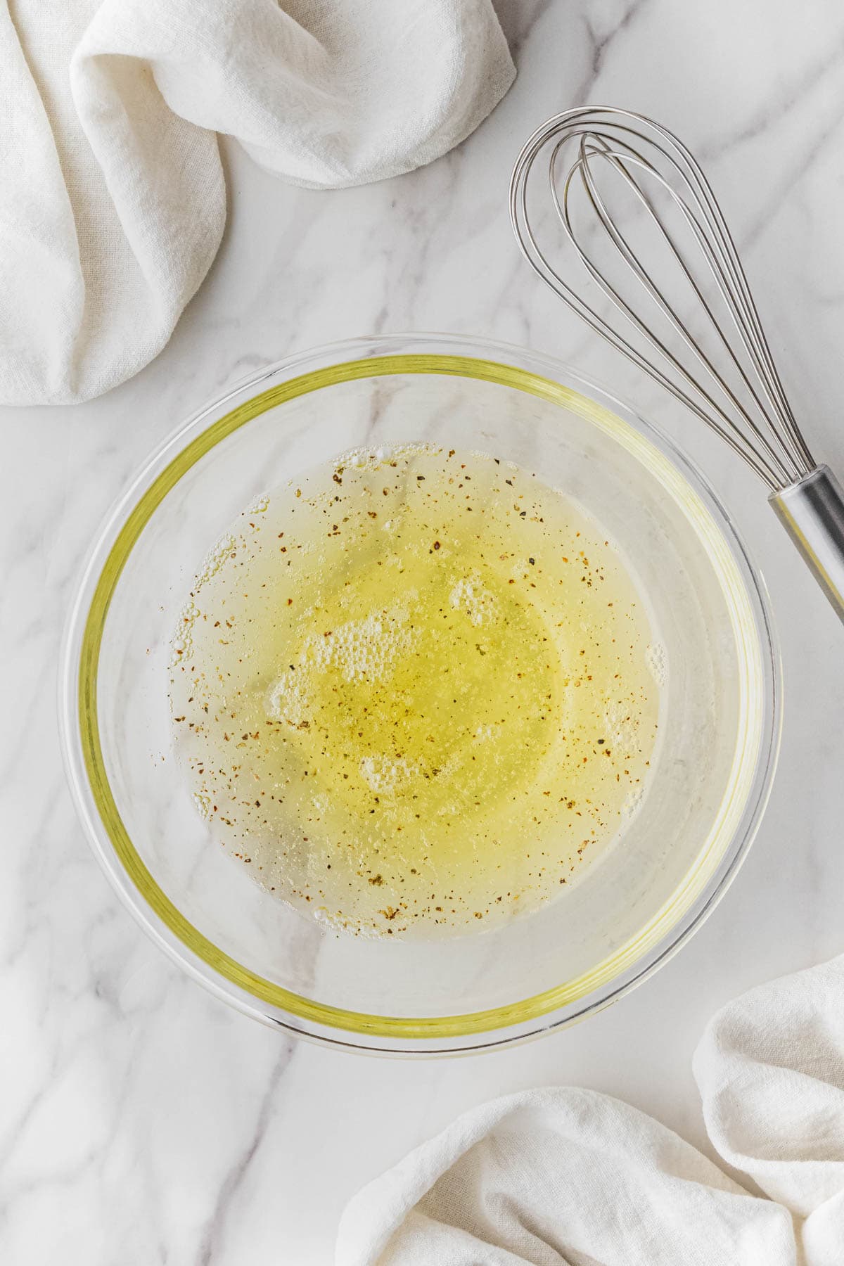 egg white mixture in clear bowl with whisk on side