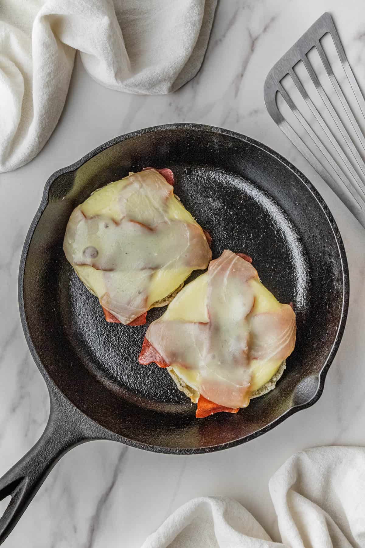 melted white cheddar cheese on ingredients in skillet