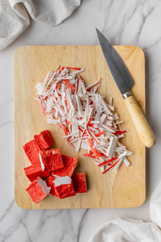 chopped imitation crab meat on wooden cutting board