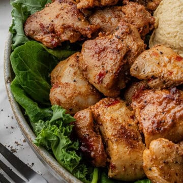 close up of Cava Honey Harissa Chicken on a bed of greens