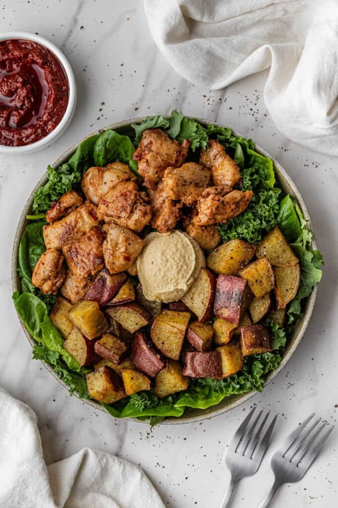 Cava Honey Harissa Chicken recipe on a bed of greens
