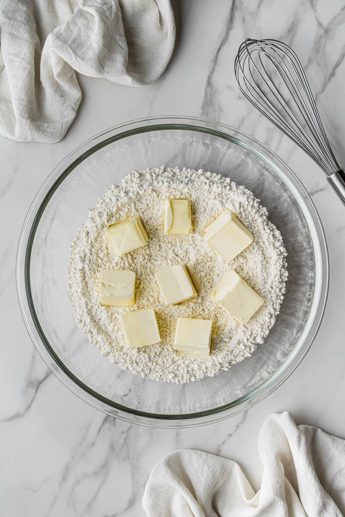 overhead view of butter and flour in clear bowl