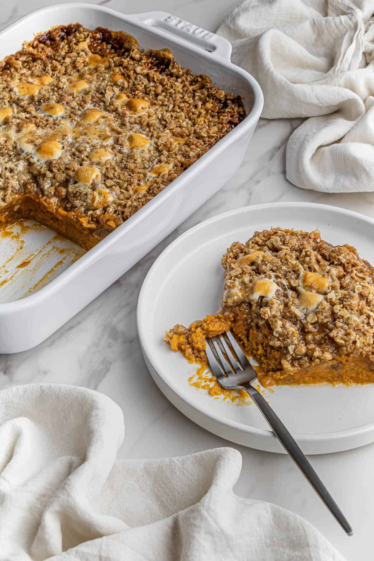 Boston Market Sweet Potato Casserole recipe on white plate with fork with casserole dish beside it