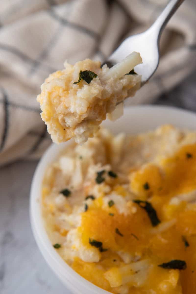 Cracker Barrel Cheesy Hash Brown Recipe crock pot in a bowl with a spoon
