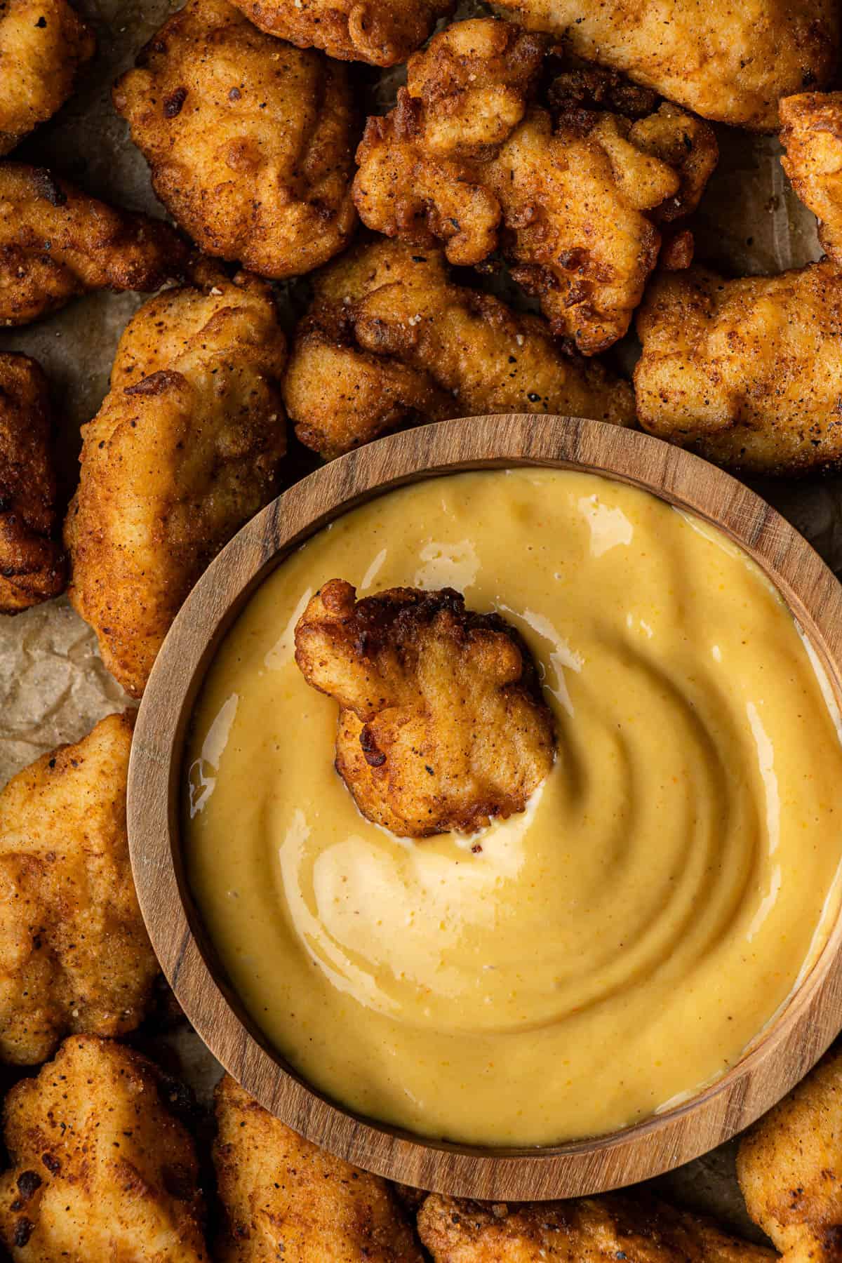 chick-fil-a sauce in wooden bowl with chicken nugget in it