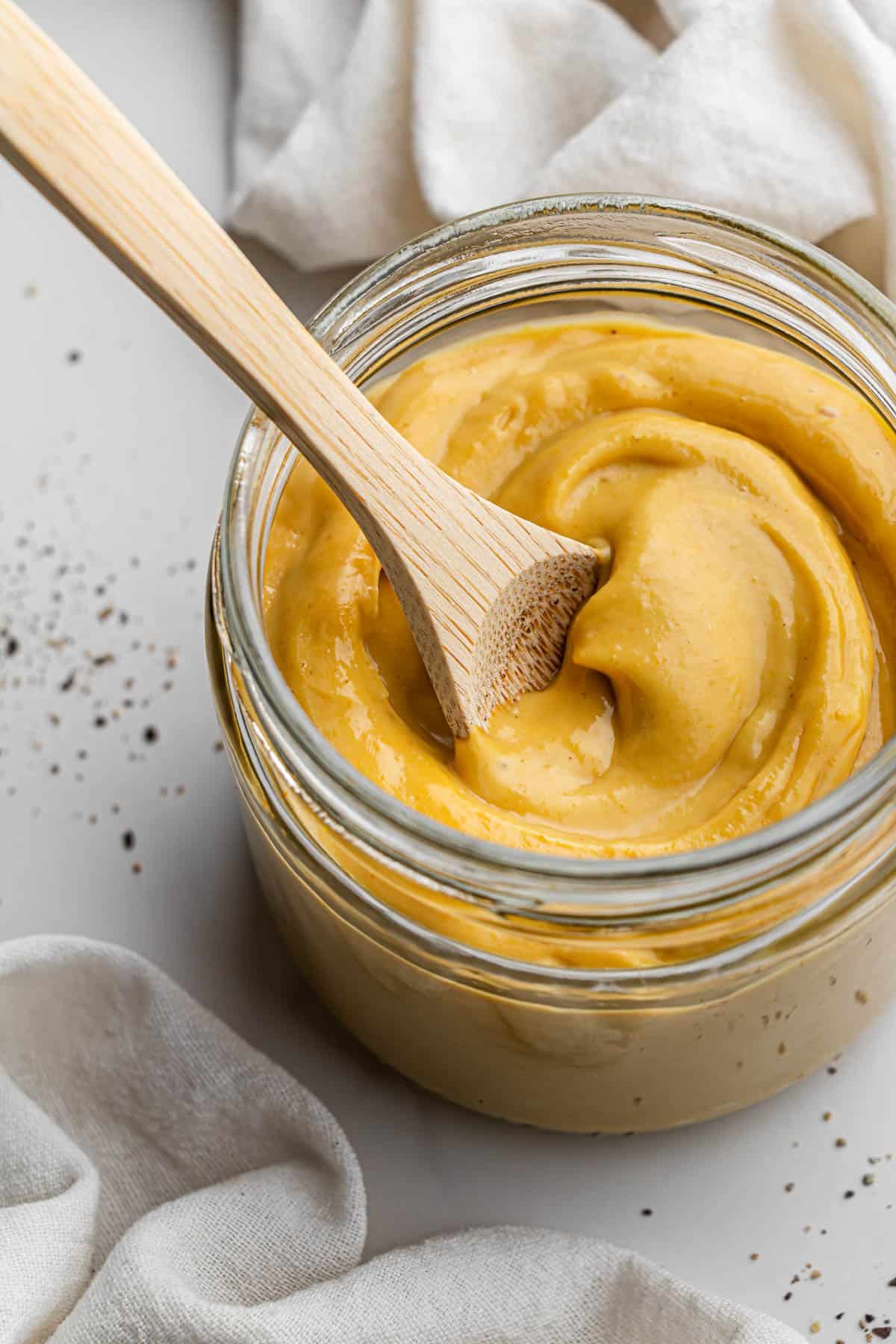 chick-fil-a sauce copycat recipe in a clear jar with wooden spoon