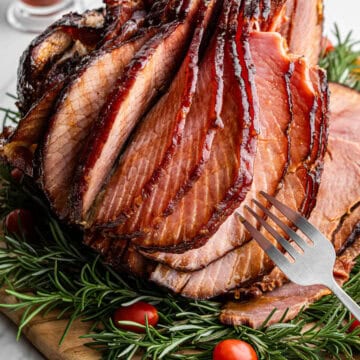 honey baked ham with silver fork grabbing a slice