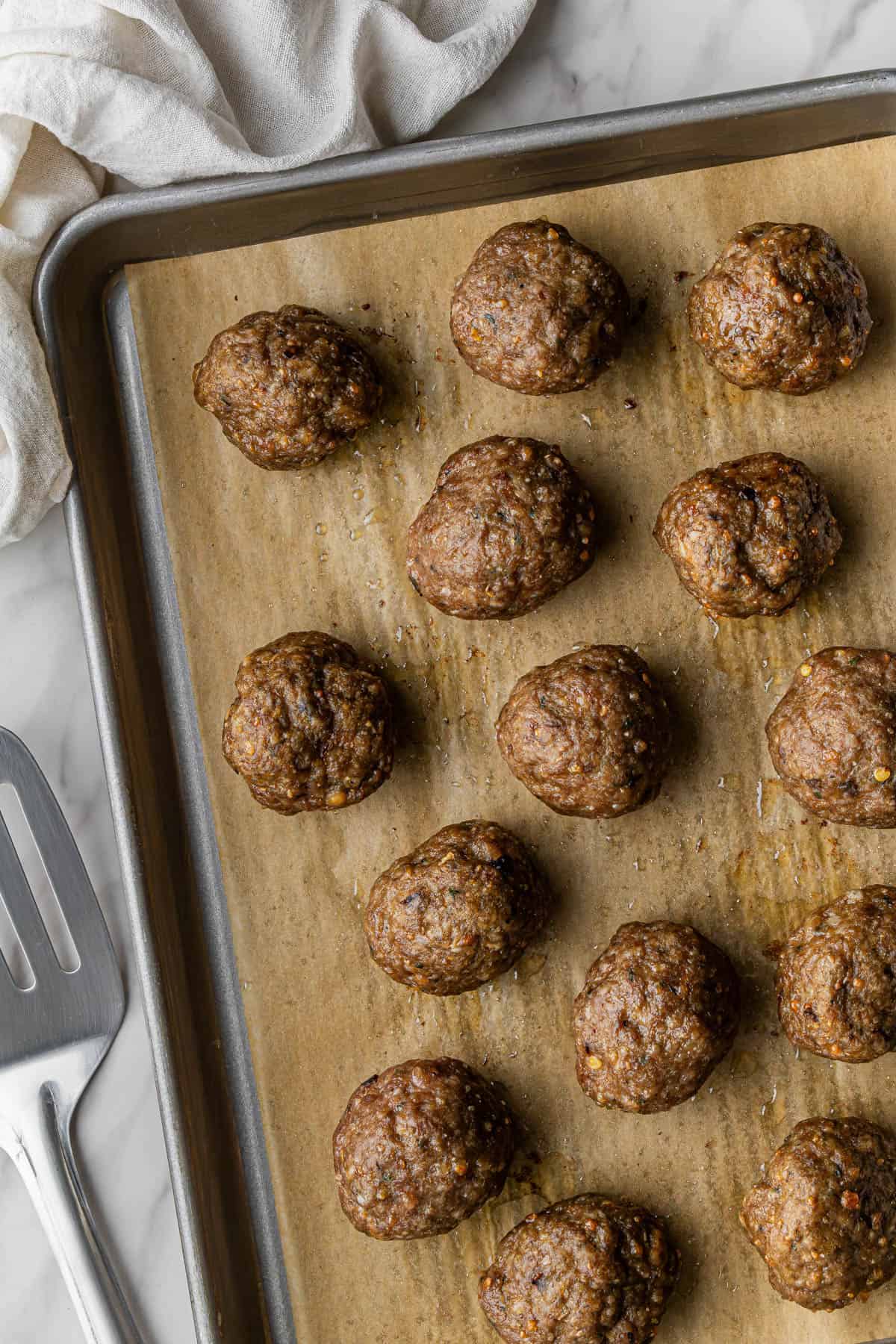 olive garden meatballs recipe on a baking sheet lined with parchment paper