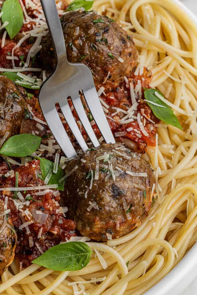 a fork in the olive garden spaghetti and meatballs recipe on a plate