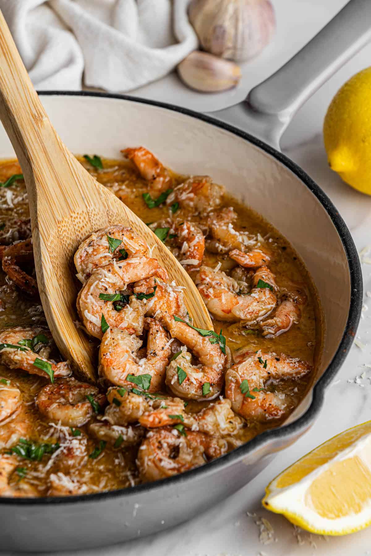Red Lobster Shrimp Scampi copycat recipe in white skillet with wooden spoon holding shrimp