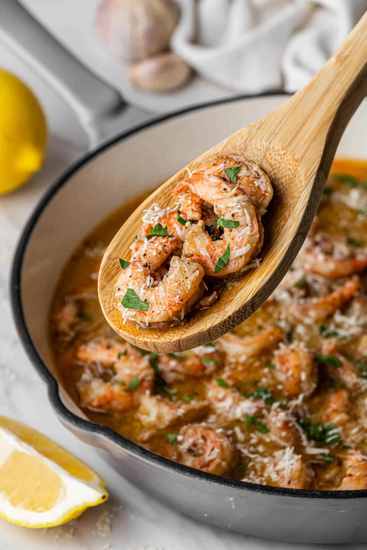 Red Lobster Shrimp Scampi copycat recipe in white skillet with wooden spoon holding shrimp