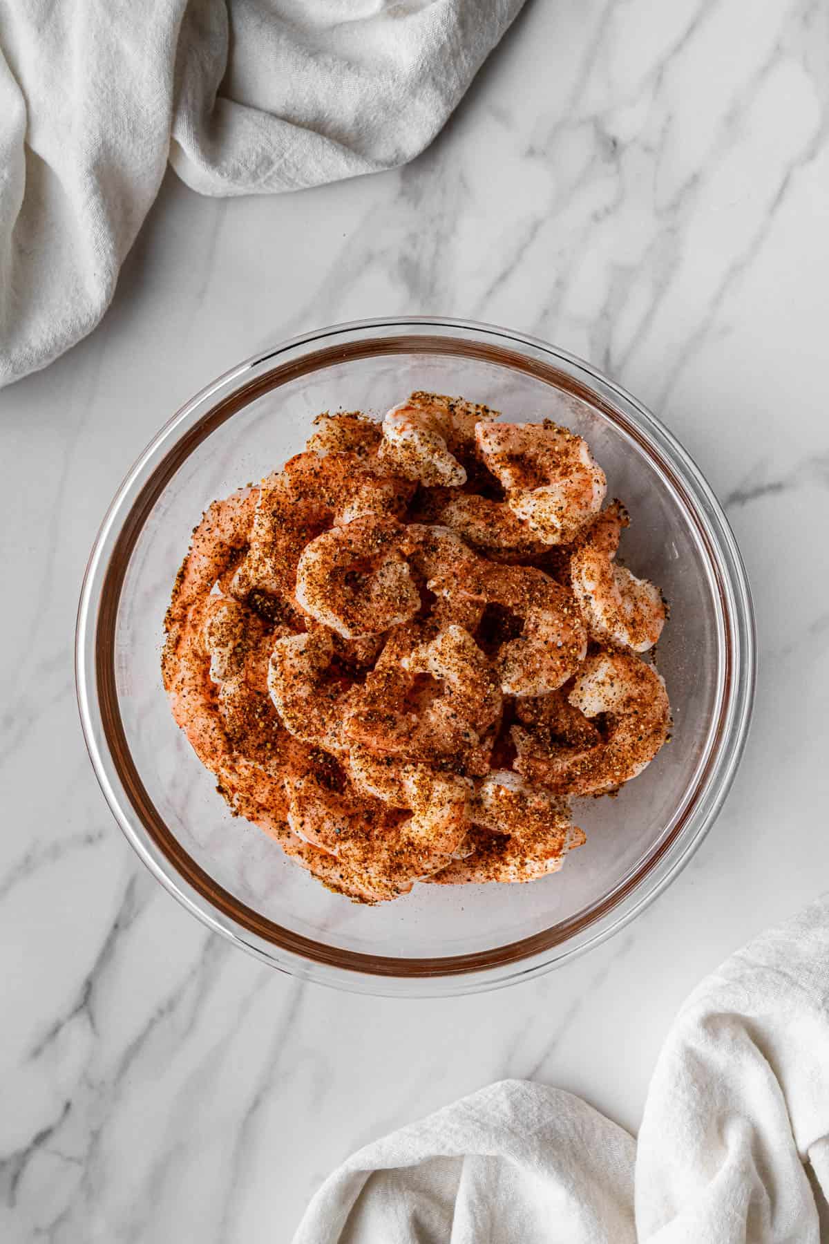 raw meat covered in seasonings in clear bowl