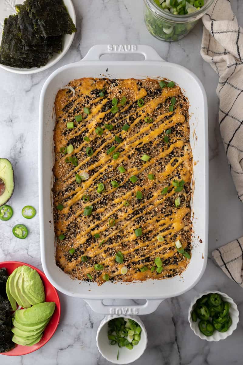 rice and seafood layered in a baking dish with toppings fully cooked