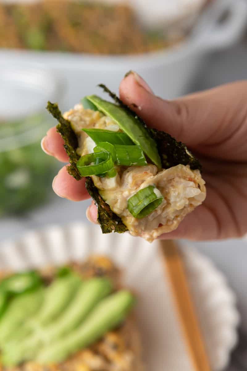 close up shot of the sushi bake recipe being picked up by nori sheets